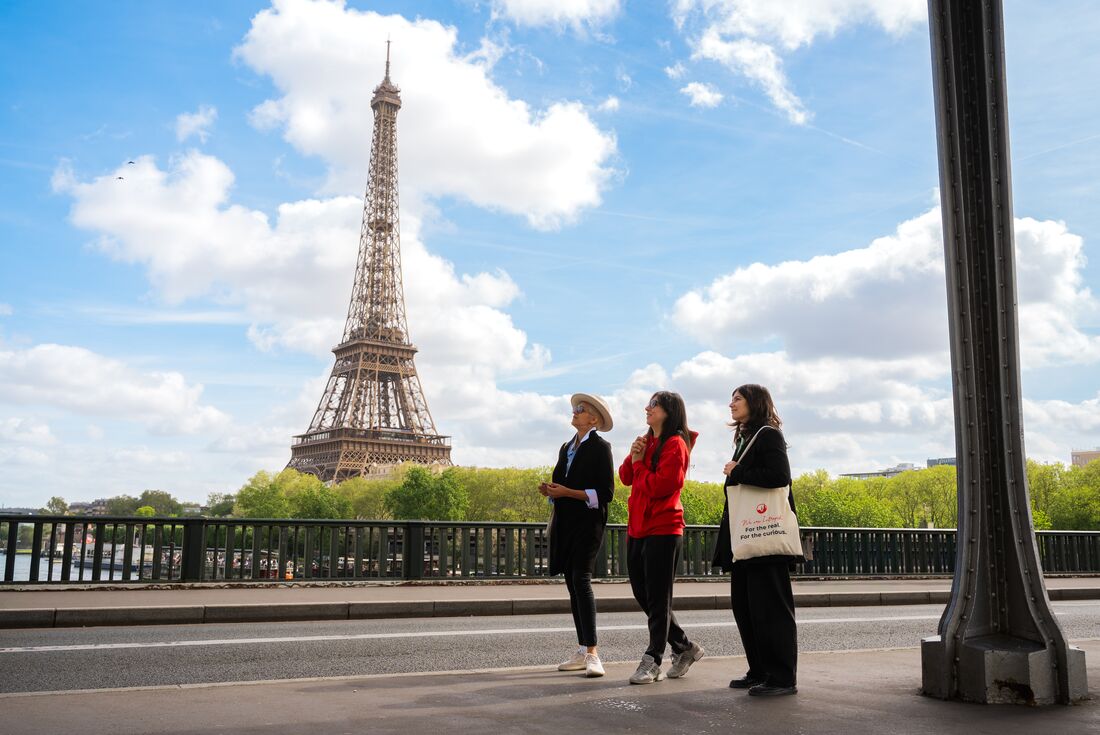 Travellers walk by the Eiffel Tower with Intrepid Leader