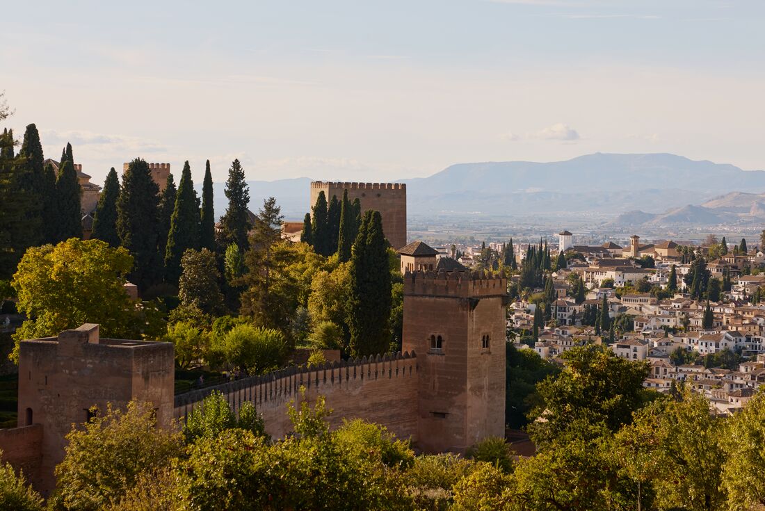 Alhambra fortress with nearby town and mountains in the background in Granada, Spain
