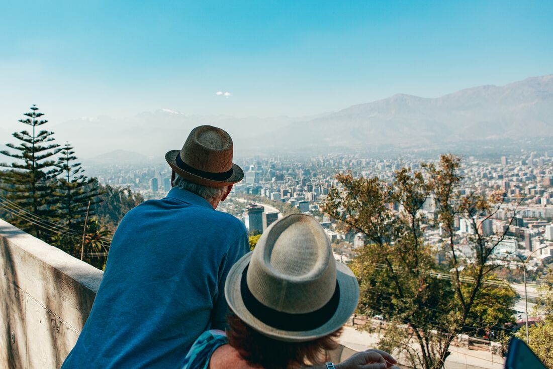 Intrepid Travellers look out over the city skyline of Santiago, Chile, surrounded by hazy mountains