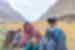 Traveller posing with local family with mountains in the background, Pakistan