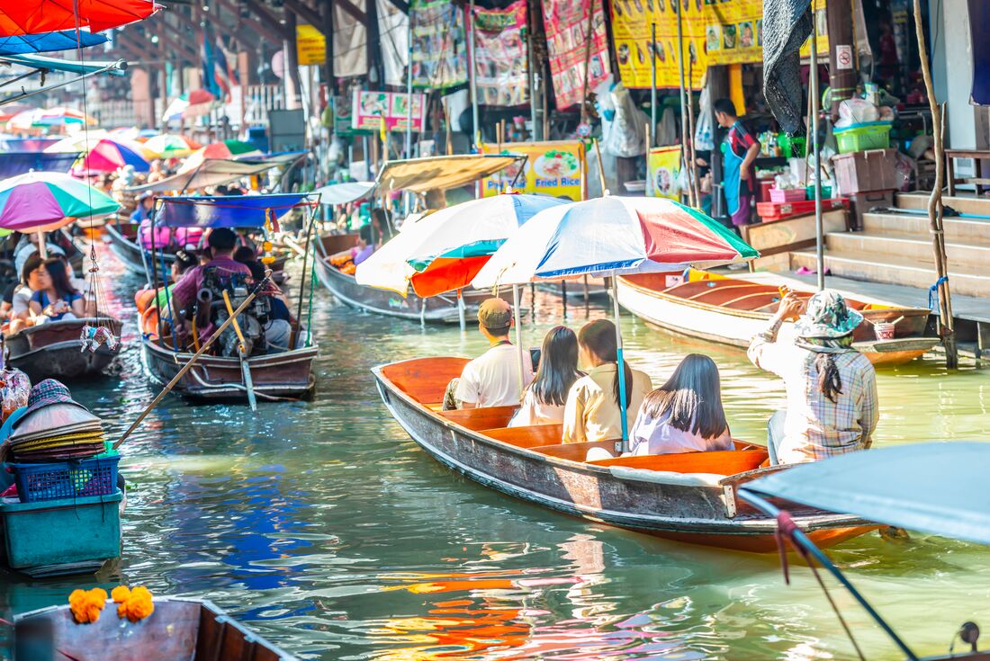 Travellers on a boat exploring the Damnoen Saduak floating market, Bangkok, Thailand