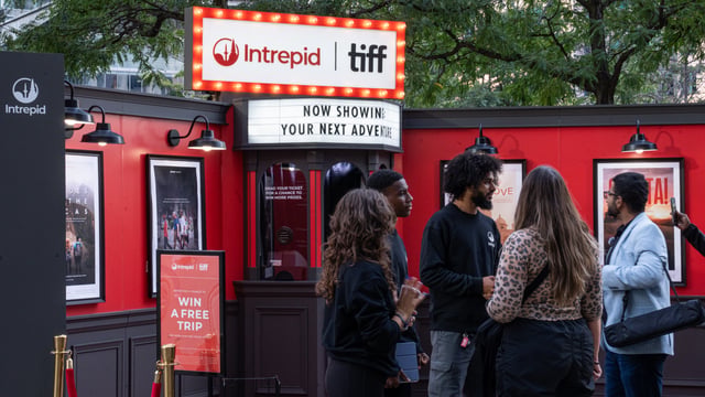 People standing in front of an Intrepid x TIFF booth