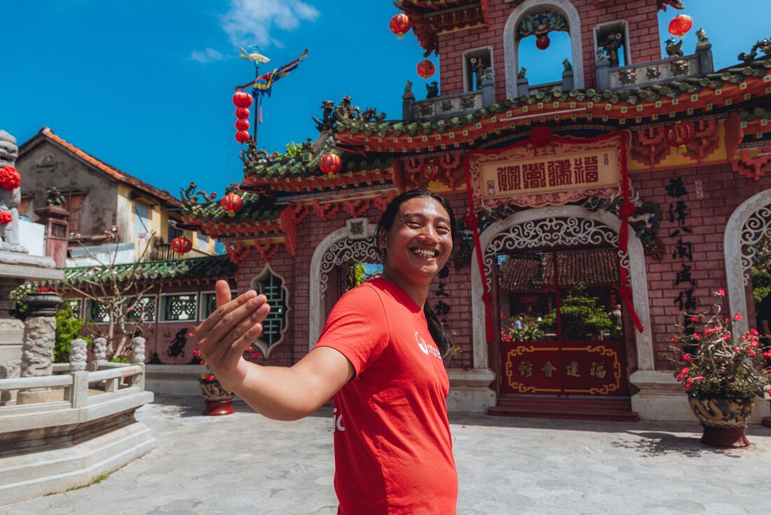 Leader smiles back at camera as he takes travellers to Fujian Assembly Hall in Hoi An, Vietnam