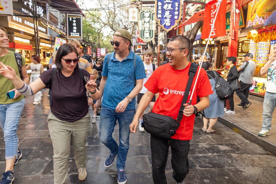 Leader laughing with traveller group in the Muslim Quarter in Xi'an, China
