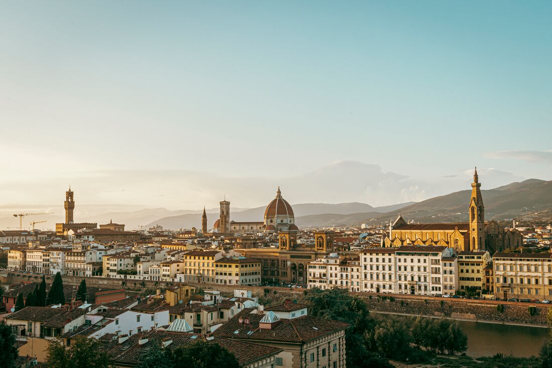 Wide view of the city of Florence during sunset with mountain landscape in the distance, Italy