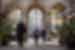 Locals walking through a building with three impressive archways in Barcelona, Spain.