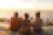Travellers chat while sitting on the cliffs of Cape Town at sunset